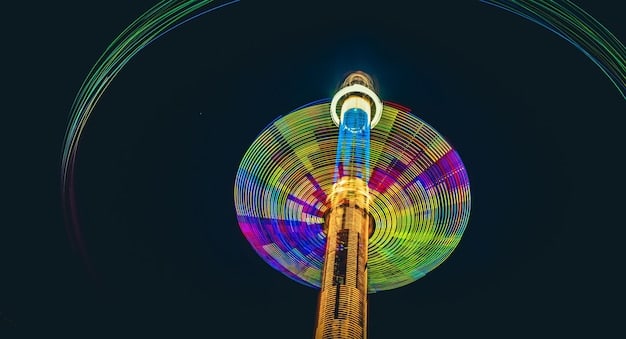 A vibrant and colorful image of the N Seoul Tower at night, showcasing the illuminated tower against the Seoul skyline and the love locks fence with numerous padlocks attached.