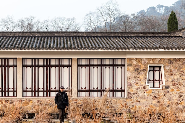 A split image showing a traditional Korean hanok (house) on one side and an American suburban home on the other, connected by a wavy line symbolizing the cultural crossover. A TV screen showing K-drama characters is superimposed near the American home.