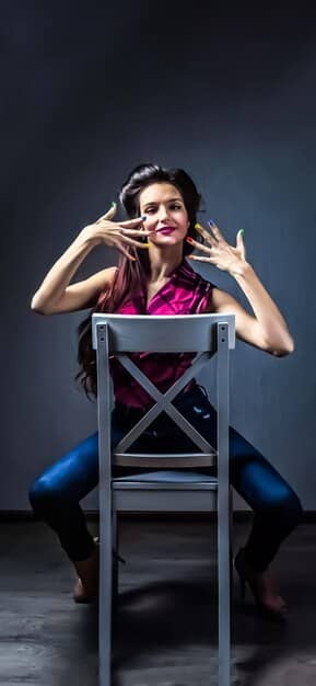 A celebrity slumped in a chair backstage, looking utterly drained. Makeup is smudged, expression forlorn, capturing the exhaustion of a long performance or shoot.
