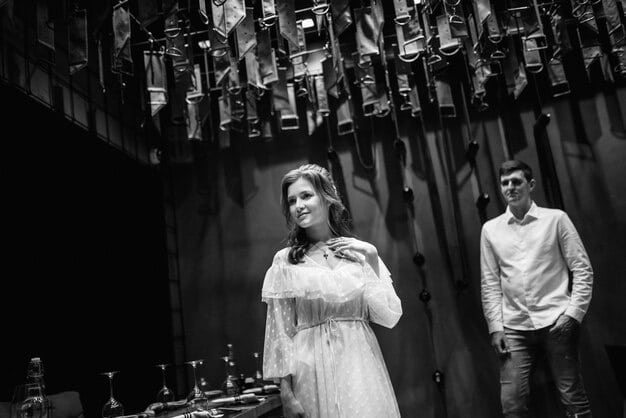 A black and white scene from an old TV drama, showcasing the actors in vintage costumes and the classic set design. The scene captures a dramatic moment, reflecting the storytelling style of early television.