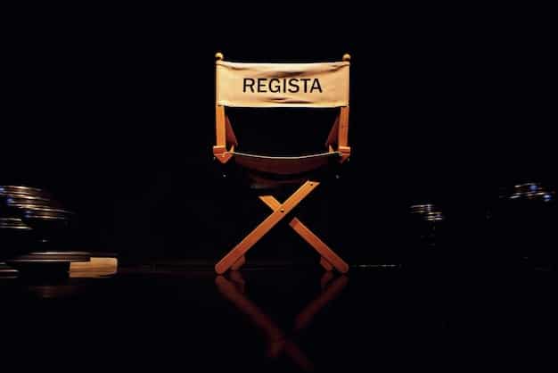 A close-up shot of a director's chair on a film set, with script pages scattered around and the camera slightly out of focus in the background, symbolizing the behind-the-scenes aspect of drama news.