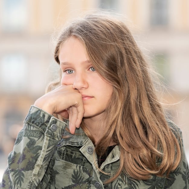 A close-up shot of Millie Bobby Brown as Eleven, looking determined and focused. The background is blurred, emphasizing her emotional intensity.