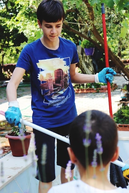 A K-drama actor participating in a community clean-up event, wearing a branded t-shirt related to sustainable film production. They are smiling and engaged, demonstrating a commitment to ethical and environmental practices, reflecting the industry's growing consciousness.